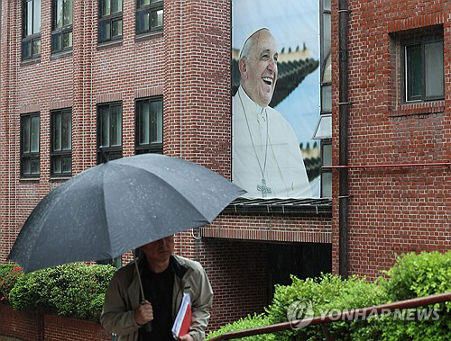 21일 선종한 프란치스코 교황의 걸개 사진이 걸린 서울 중구 명동성당. 22일 명동성당에 프란치스코 교황의 빈소가 마련돼 일반인들이 교황을 추모할 수 있다. 연합뉴스